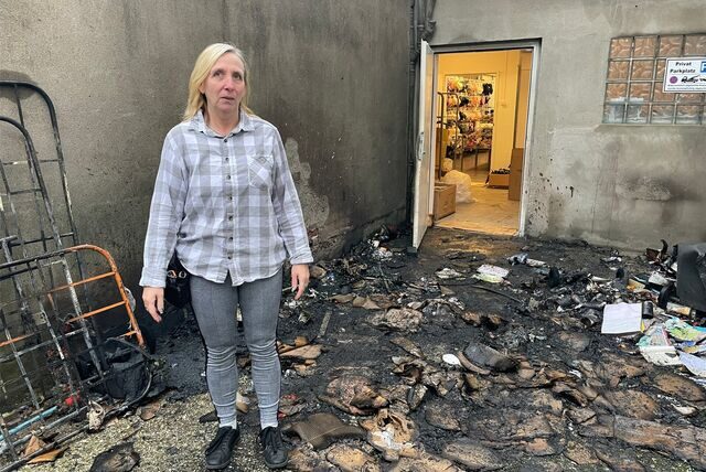 KiK-Mitarbeiterin Susanne Schilk steht in den Überresten des nächtlichen Feuers in der Dorstener Altstadt.