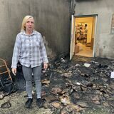 KiK-Mitarbeiterin Susanne Schilk steht in den Überresten des nächtlichen Feuers in der Dorstener Altstadt.