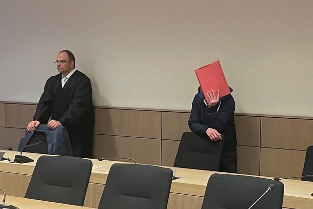 Ein Gelegenheitsarbeiter aus Herne (rechts) verdeckt durch einen roten Ordner im Gerichtssaal.