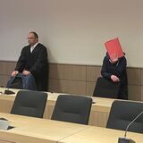 Ein Gelegenheitsarbeiter aus Herne (rechts) verdeckt durch einen roten Ordner im Gerichtssaal.