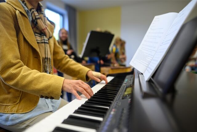 Eine Lehrerin spielt im Musikunterricht Piano. (Symbolbild)