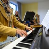 Eine Lehrerin spielt im Musikunterricht Piano. (Symbolbild)