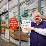 Wilfried Krull zeigt einen seiner Flyer „Rettet unsere City“ vor dem ehemaligen Rewe-Markt in der Stadtgalerie.
