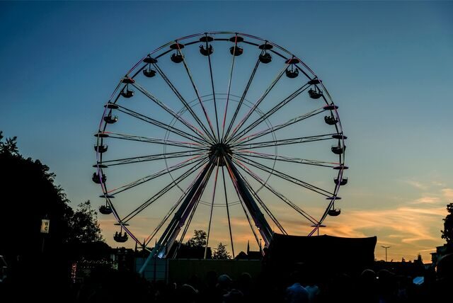 Ein Riesenrad im Sonnenuntergang auf dem Parkfestgelände.