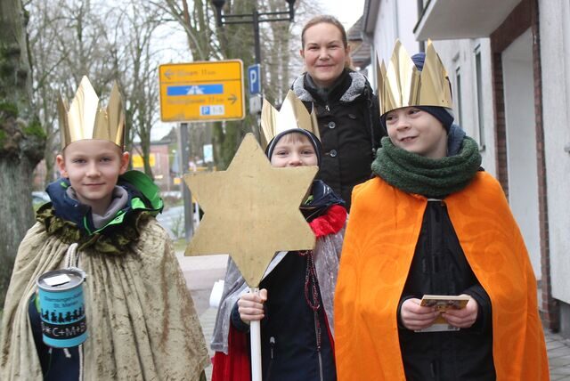 Julian Link, Karl Bauernfeind und Mika Rosendahl, begleitet von Anika Link (hinten), sind in Drei-Heilige-Könige-Montur in Waltrop unterwegs.