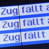 „Zug fällt aus“ steht auf einer Anzeigetafel in einem Bahnhof (Symbolbild).