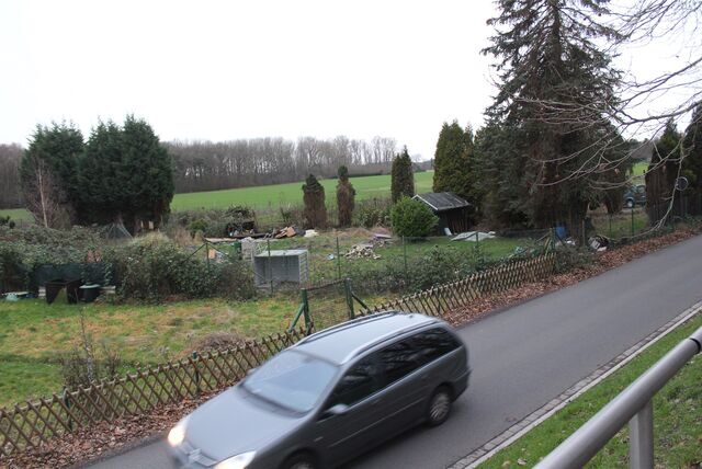 Ein Auto fährt an einer Kleingartenparzelle vorbei an der Straße Am Felling in Waltrop.