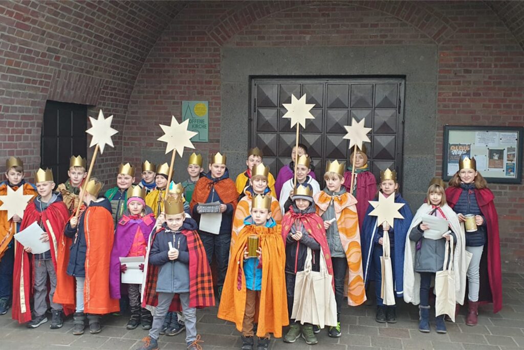 Die Sternsinger im Gewnad vor der Heilig-Kreuz-Kirche