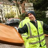 Ein Müllwerker wirft Sperrmüll in ein Müllfahrzeug