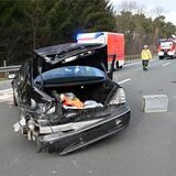 Einsatzkräfte der Feuerwehr stehen auf der A31 neben einem der verunfallten Pkw.