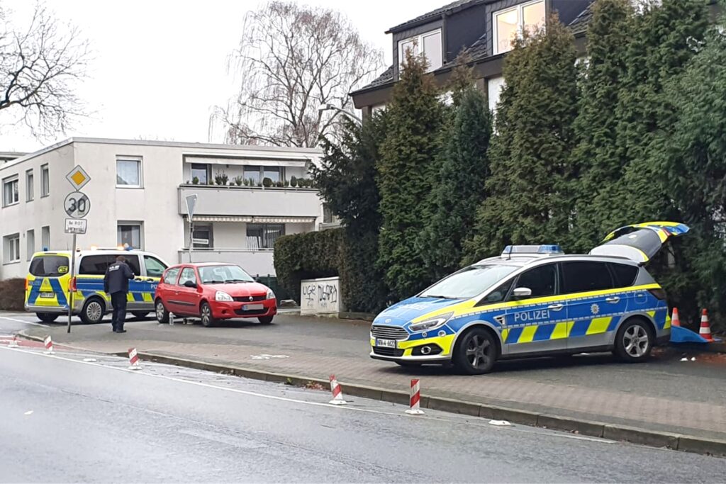 Mehrere Streifenwagen befinden sich in Herten an der Ecke Beethovenstraße/Über den Knöchel. Hinter dem Einsatzfahrzeug liegen Beweisstücke, die nach und nach gesichert werden.
