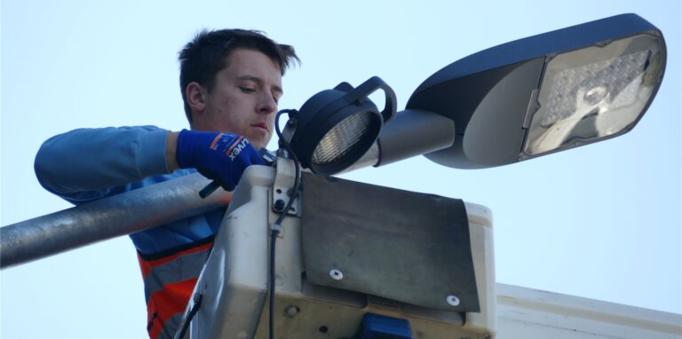 Fabio Kowalke, bei den Stadtwerken als Techniker zuständig für Straßenbeleuchtung und Hausanschlüsse, richtet in schwindelerregender Höhe die neuen LED-Lampen an der Kaiserstraße richtig aus.
