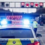 Auf einem Polizeifahrzeug leuchtet die Aufschrift „Gesperrt“.