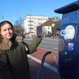 Zeynep Altuntas hält ein Handy neben dem Parkautomaten auf dem Waltroper Marktplatz in die Höhe.