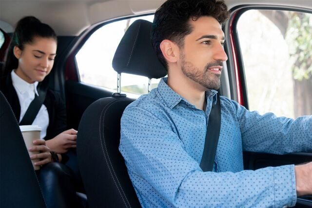 TaxischildEine Frau fährt im Taxi mit.