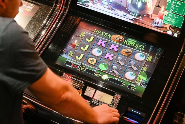 Ein Spieler sitzt in einer Spielhalle vor einem Automaten.