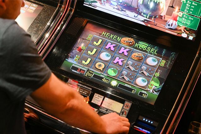Ein Spieler sitzt in einer Spielhalle vor einem Automaten.