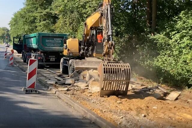 Ein Bagger reißt bei Sanierungsarbeiten in Herten einen Gehweg auf.