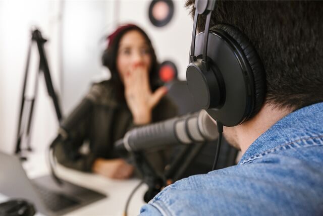 zwei menschen nehmen gemeinsam einen podcast auf