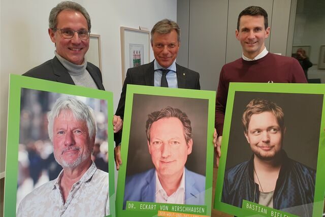 Drei Männer halten Plakate von den Comedians Jürgen Becker, Eckart von Hirschhausen und Bastian Bielendorfer in die Kamera.