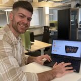 Ex-Bachelorette-Kandidat Alexandros Chouliaras aus Marl steht an einem Laptop.