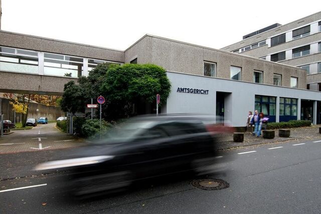 Außenansicht des Amtsgerichts Recklinghausen, davor ein vorbeifahrendes Auto in Wischoptik.