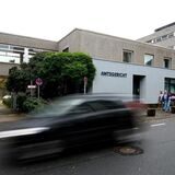 Außenansicht des Amtsgerichts Recklinghausen, davor ein vorbeifahrendes Auto in Wischoptik.