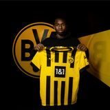 Moses Otuali hält ein BVB-Trikot in den Händen.