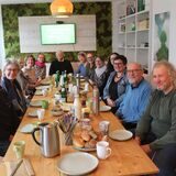 Mitglieder und Gäste des Ortsverbands von Bündnis 90/Die Grünen sitzen an einer langen Tafel beim Frühstück.