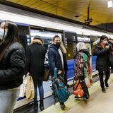 Mehrere Personen mit Maske steigen in Madrid auf dem Bahnsteig .