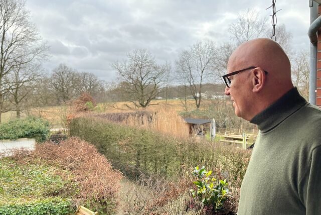 Josef Schürmann steht auf seinem Balkon und guckt in die Ferne.