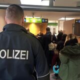Ein Polizist steht vor der Passkontrolle am Flughafen Dortmund.