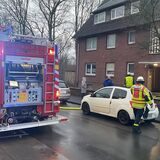 Feuerwehrfahrzeug und Feuerwehrleute stehen vor einem Mehrfamilienhaus am Ostring in Waltrop.