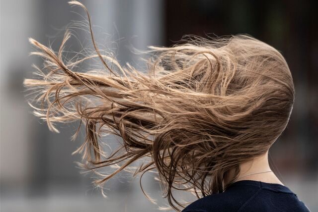 Die Haare einer Frau fliegen im Sturm.