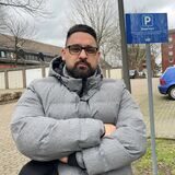 Ein LEG-Mieter steht mit verschränkten Armen auf dem Parkplatz am Händelweg.