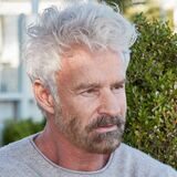 Michael Reh sitzt auf der Terrasse von einem Café.