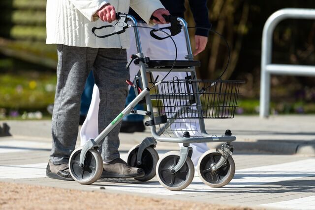 Eine Person ist mit dem Rollator unterwegs (Symbolbild)