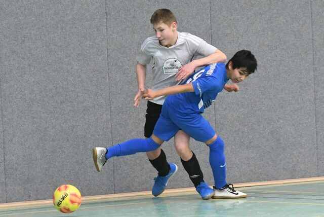 Spieler des TuS Henrichenburg (in grau) und des FC Frohlinde im Zweikampf im Finale der Castrop-Rauxeler D-Jugend-Hallenstadtmeisterschaften.