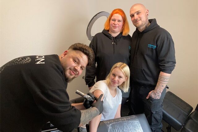 Bereits am Eröffnungstag im Studio von Nicole und Lucas Schulz (hinten) setzt Tattoo-Artist Salu die Nadel bei einer Kundin an.