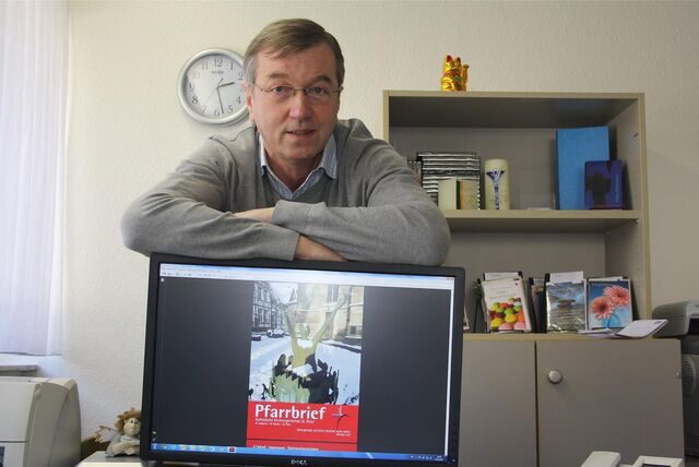Der damalige Waltroper Pfarrer Clemens Fabry stellte 2013 den neuen Pfarrbrief vor; auf dem Bild steht Fabry hinter einem Bildschirm, auf dem das Cover des Pfarrbriefs zu sehen ist.