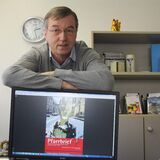 Der damalige Waltroper Pfarrer Clemens Fabry stellte 2013 den neuen Pfarrbrief vor; auf dem Bild steht Fabry hinter einem Bildschirm, auf dem das Cover des Pfarrbriefs zu sehen ist.