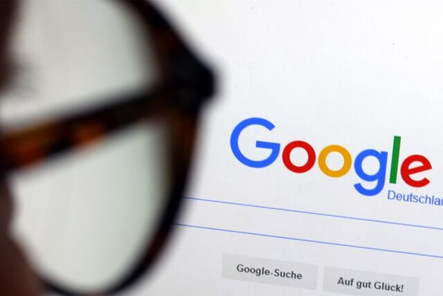 Die Seite der Suchmaschine von Google ist hinter einer Frau mit Brille zu sehen.
