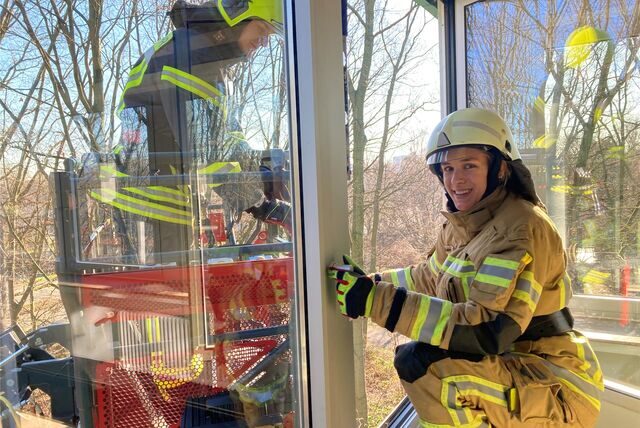 Die angehende Feuerwehrfrau Hannah Heilmann klettert aus einem Fenster des Medienhauses Bauer in Marl in den Drehleiterkorb zu ihrem Kollegen Fabian Wordel. Das Foto entstand bei einer Übung im Rahmen der Feuerwehrausbildung im Februar 2023.
