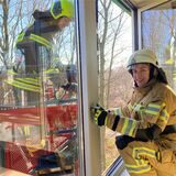 Die angehende Feuerwehrfrau Hannah Heilmann klettert aus einem Fenster des Medienhauses Bauer in Marl in den Drehleiterkorb zu ihrem Kollegen Fabian Wordel. Das Foto entstand bei einer Übung im Rahmen der Feuerwehrausbildung im Februar 2023.