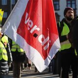 Demonstranten halten eine Verdi-Flagge