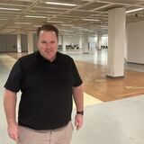Fashion-Outlet-Geschäftsführer Kristofer Jürgensen steht in einem großen leer stehenden Ladenlokal.