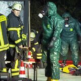 Ein Mitglied der ABC-Sondereinheit der Feuerwehr Dortmund in einem Ganzkörper-Schutzanzug vor dem Hallenbad Brackel
