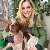 Eine Frau aus Recklinghausen hat einen mittelgroßen braun-weißen Hund auf dem Schoß.