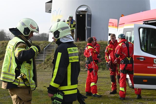 Feuerwehrleute vor einer Windkraftanlage