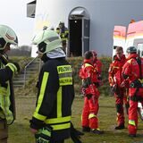 Feuerwehrleute vor einer Windkraftanlage